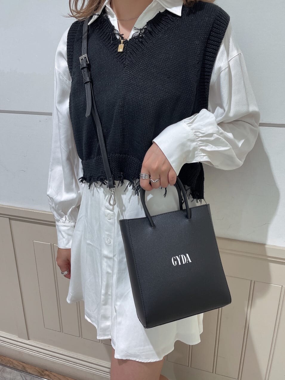 ホワイト系のワンピース、ブラック系のブーツ、ブラック系のショルダーバッグを着用したレディースの秋コーディネートの3枚目の写真