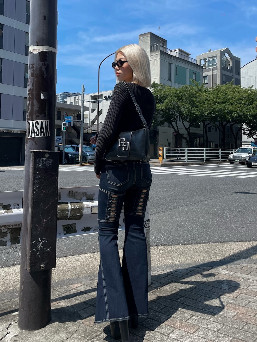 ブラック系のニット/セーター、ブルー系のデニムパンツ、ブラック系のブーツを着用したレディースの秋コーディネートの3枚目の写真