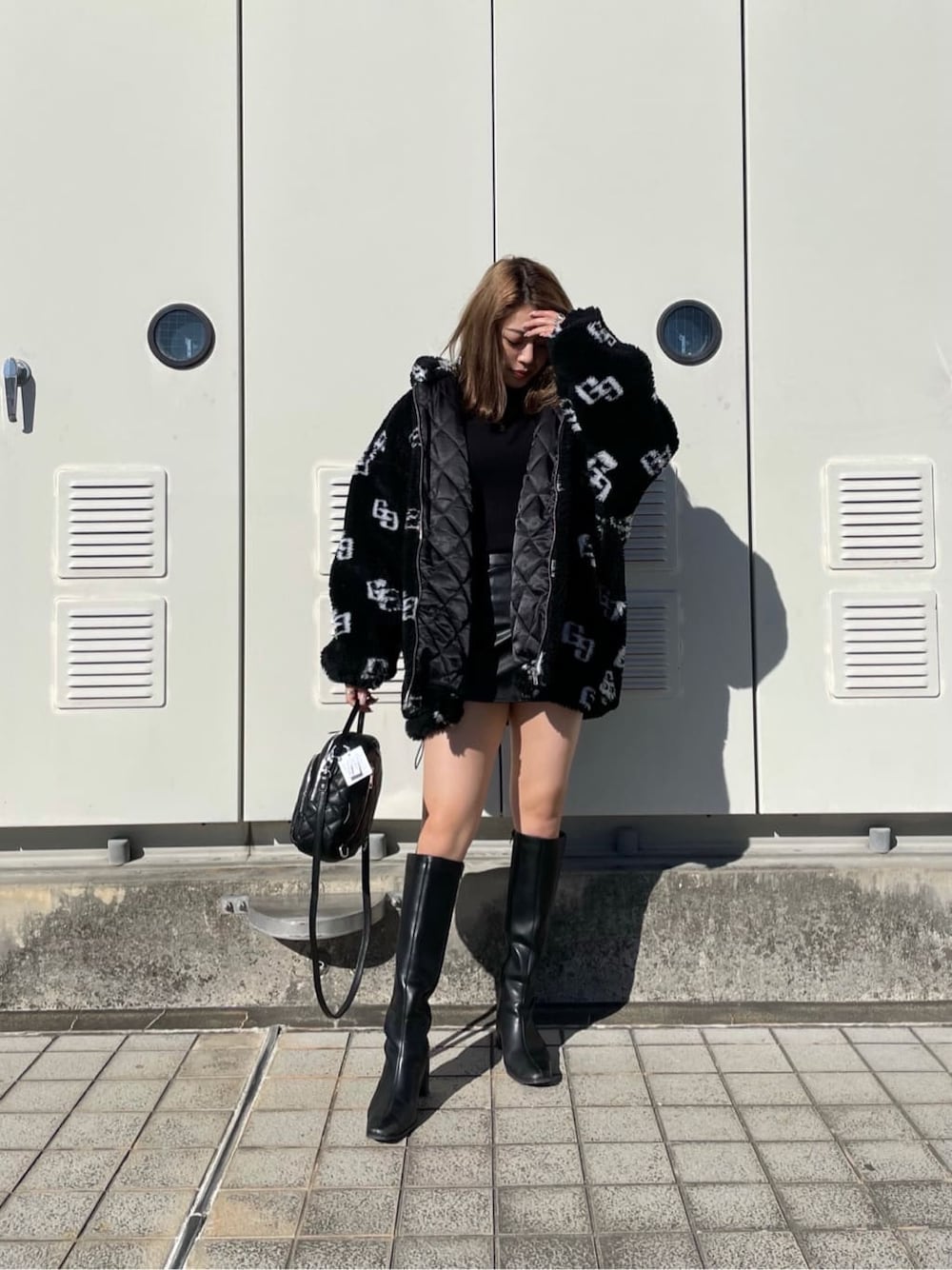 ブラック系のニット/セーター、ブラック系のブーツ、ブラック系のスカートを着用したレディースの秋コーディネートの3枚目の写真