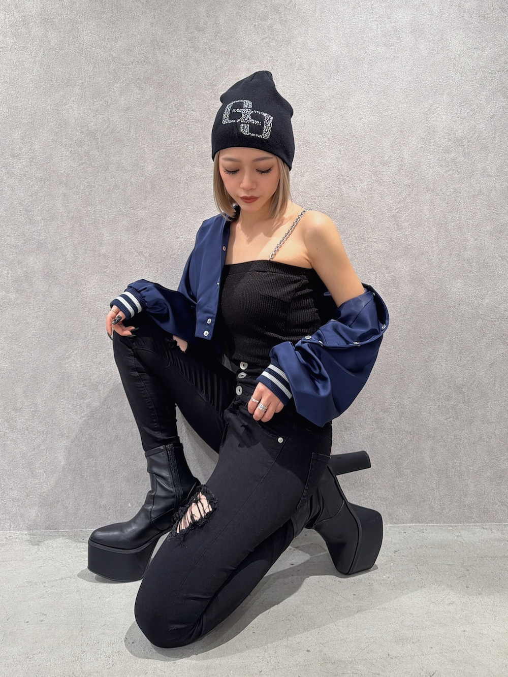 ブルー系のブルゾン、ブラック系のデニムパンツ、ブラック系のブーツを着用したレディースの春コーディネートの2枚目の写真