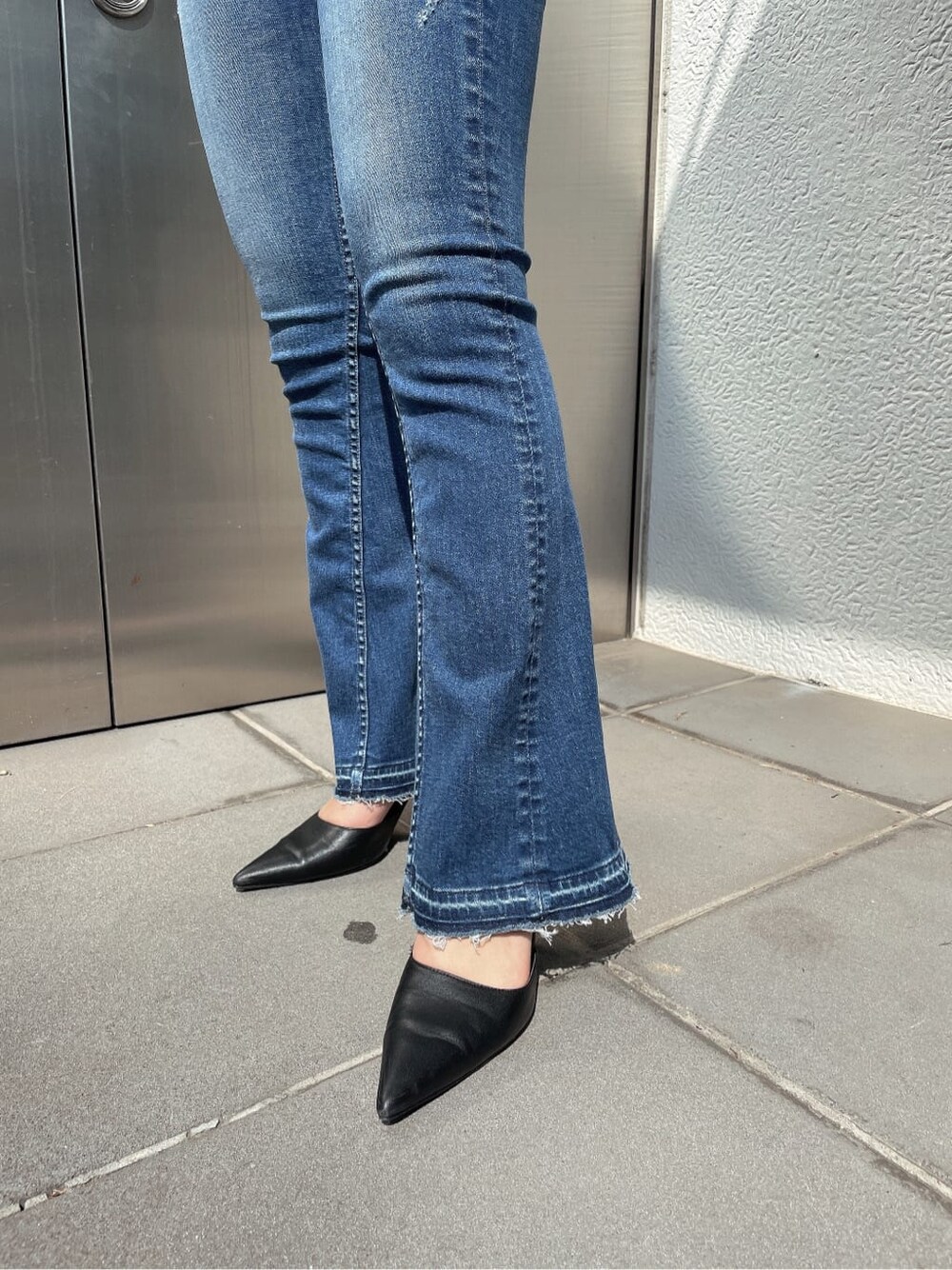 ブラック系のパンプス、ブルー系のデニムパンツ、ブラック系のニット/セーターを着用したレディースの春コーディネートの7枚目の写真