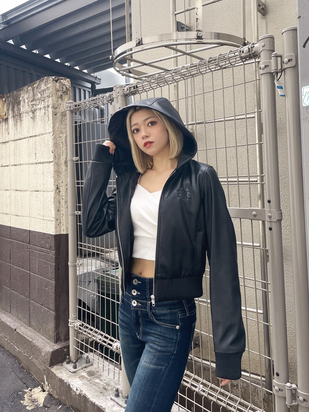 ブラック系のブルゾン、ブルー系のデニムパンツ、ホワイト系のTシャツ/カットソーを着用したレディースの春コーディネートの3枚目の写真