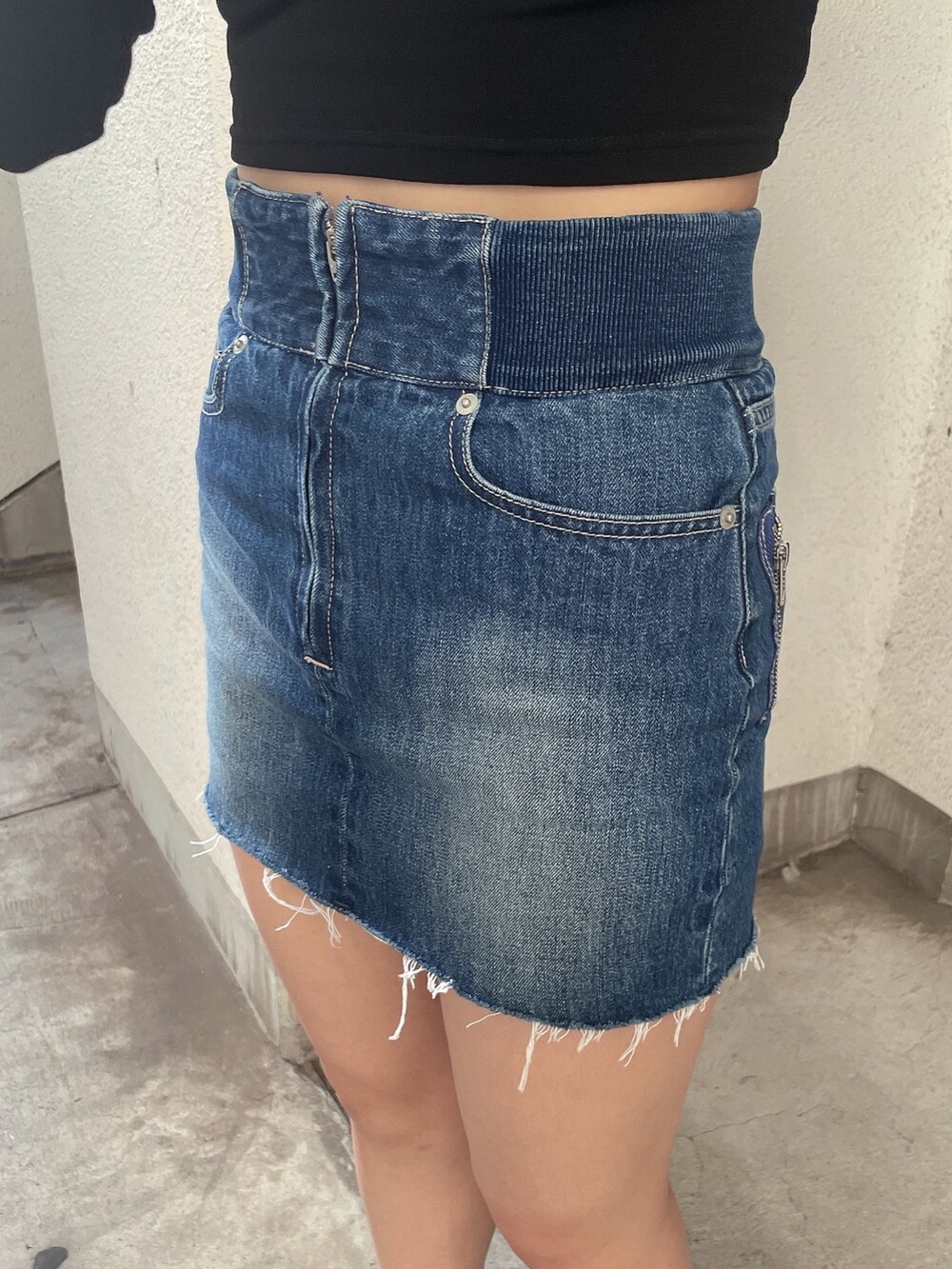 ブラック系のブルゾン、ブルー系のデニムスカート、ブラック系のスニーカーを着用したレディースの秋コーディネートの7枚目の写真