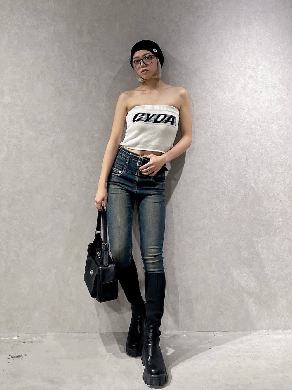 ホワイト系のニット/セーター、ブルー系のデニムパンツ、ブラック系のブーツを着用したレディースの夏コーディネートの2枚目の写真