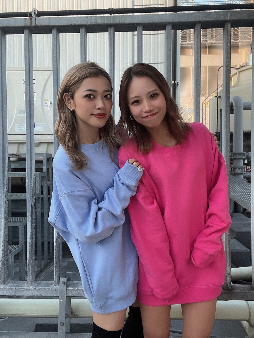 ピンク系のスウェット、ブラック系のブーツ、ブルー系のスウェットを着用したレディースの秋コーディネートの3枚目の写真