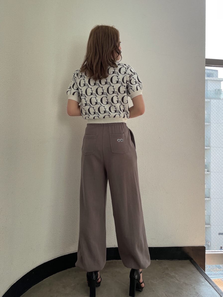 ブラック系のパンプス、ベージュ系のスウェットパンツ、ホワイト系のニット/セーターを着用したレディースの春コーディネートの4枚目の写真