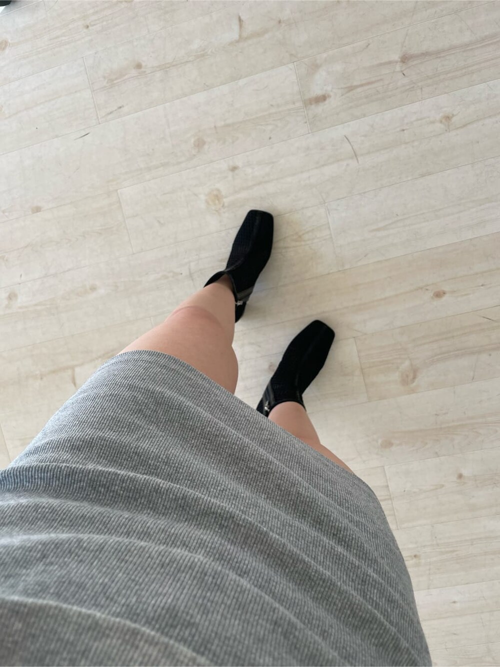 グレー系のスカート、ブラック系のブーツ、ブラック系のライダースジャケットを着用したレディースの冬コーディネートの7枚目の写真