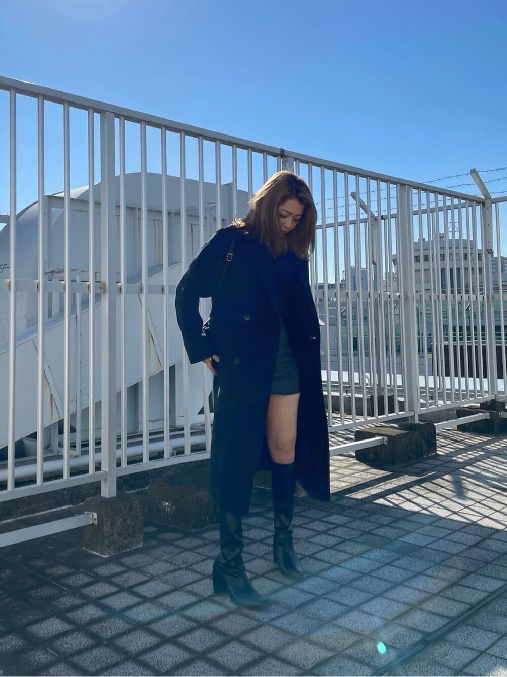 ブラック系のブーツ、ブラック系のニット/セーター、ブラック系のチェスターコートを着用したレディースの秋コーディネートの2枚目の写真