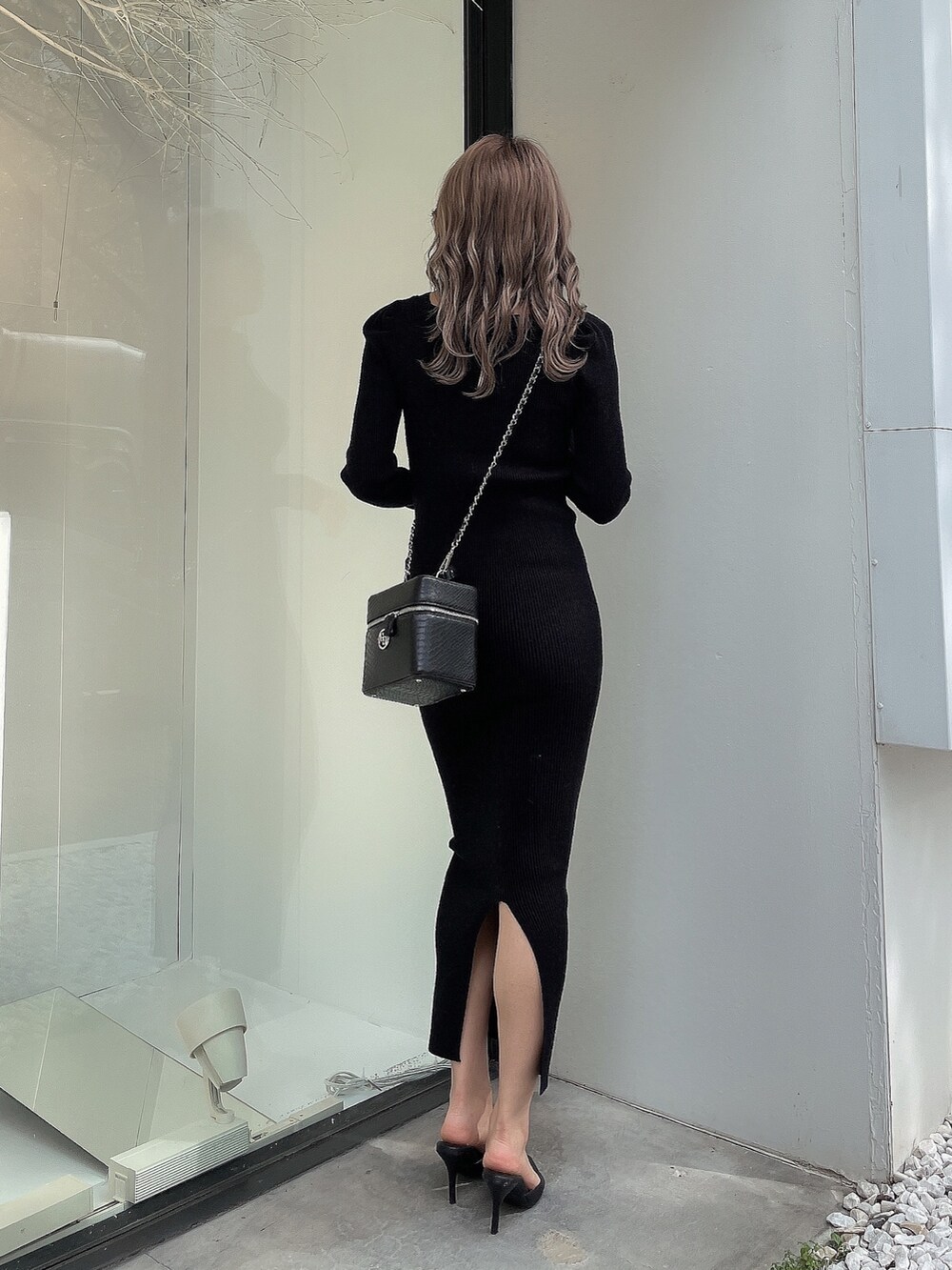 ブラック系のワンピース、ブラック系のハンドバッグ、ブラック系のパンプスを着用したレディースの秋コーディネートの4枚目の写真