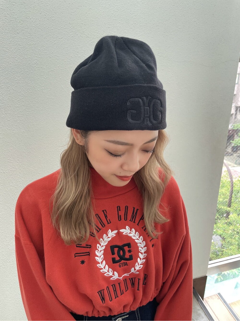 ブラック系のパンプス、ブルー系のデニムパンツ、オレンジ系のスウェットを着用したレディースの夏コーディネートの5枚目の写真