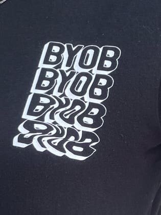 グレー系のスカート、ブラック系のTシャツ/カットソー、ブラック系の財布を着用したレディースの夏コーディネートの5枚目の写真