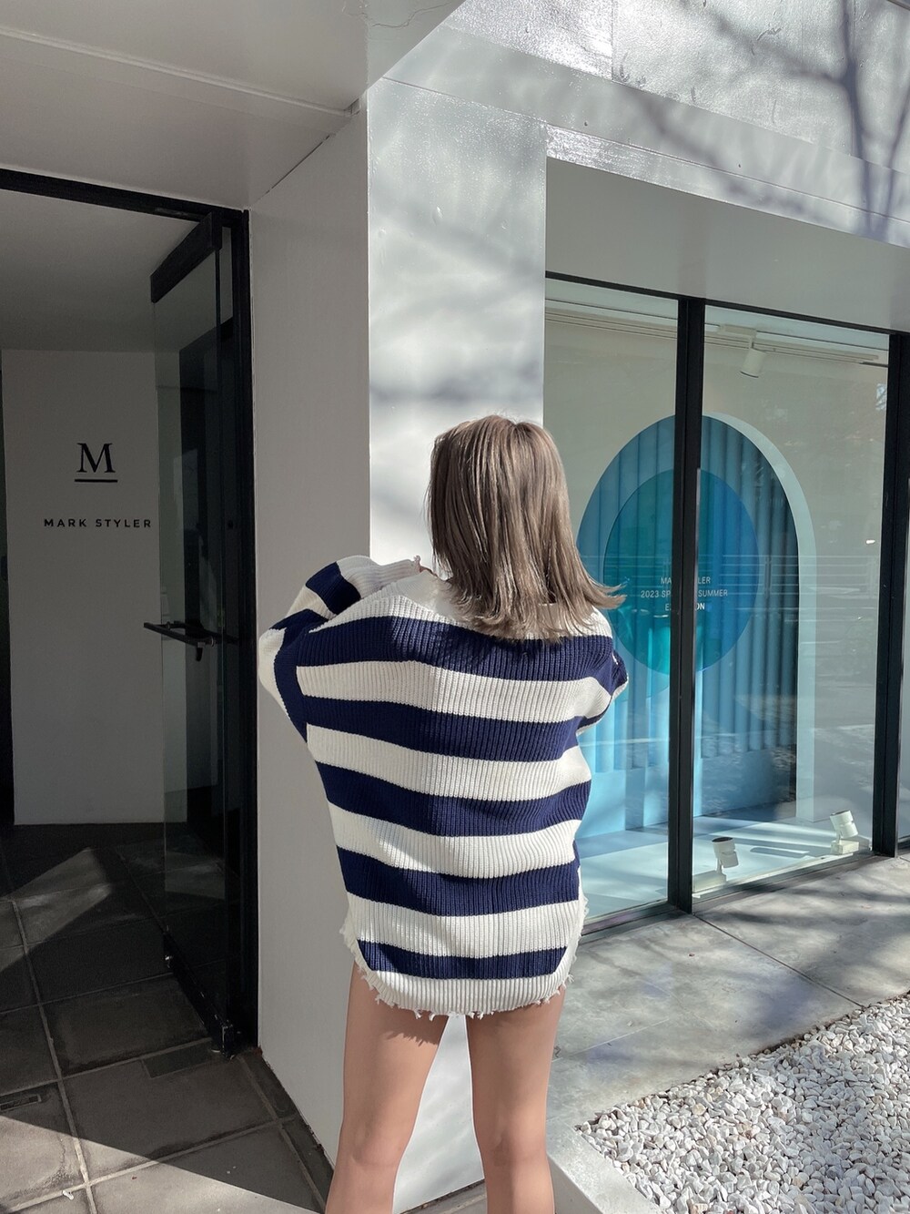 ブルー系のカーディガン/ボレロ、ブラック系のチューブトップ、ブルー系のデニムパンツを着用したレディースの冬コーディネートの5枚目の写真