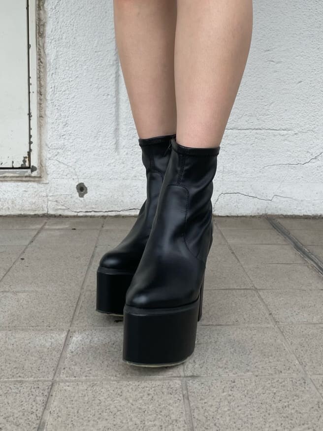 ブルー系のワンピース、ブラック系のブーツ、ブラック系のハットを着用したレディースの夏コーディネートの6枚目の写真