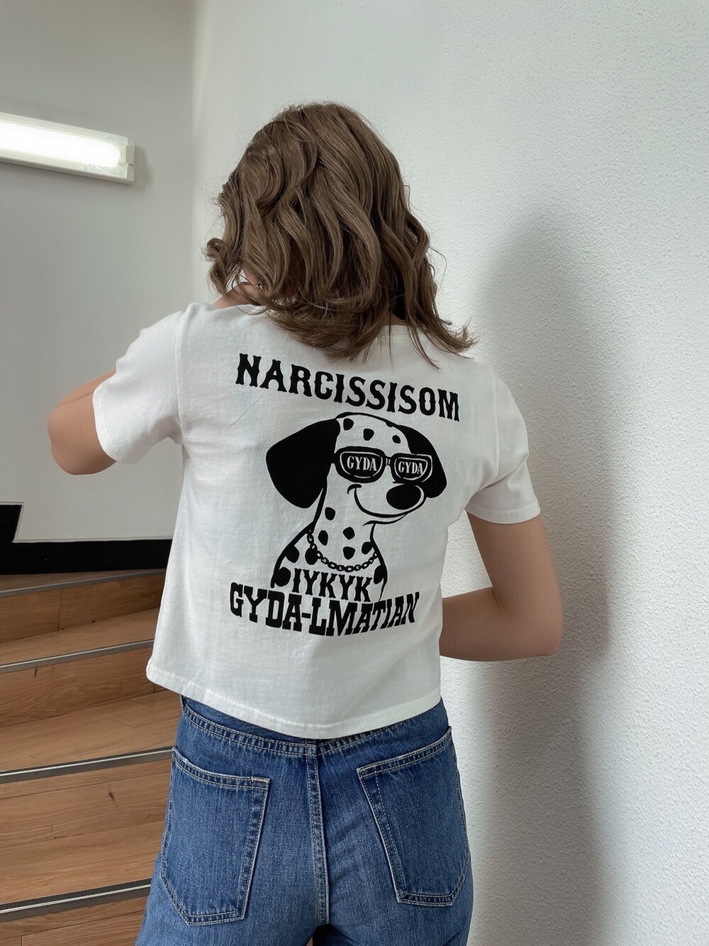 ホワイト系のTシャツ/カットソー、ブルー系のデニムパンツ、ホワイト系のパンプスを着用したレディースの春コーディネートの3枚目の写真