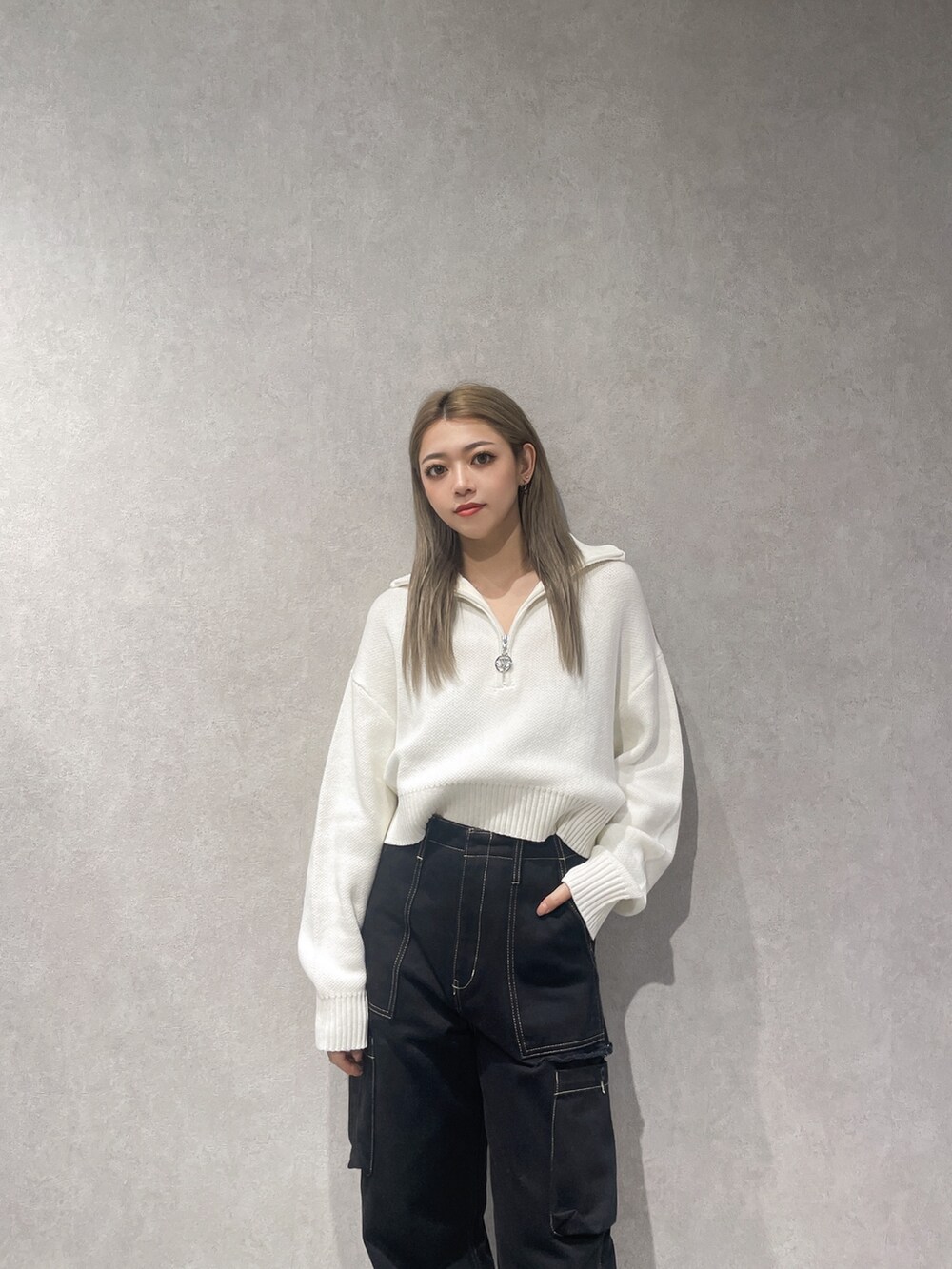 ホワイト系のニット/セーター、ブラック系のカーゴパンツ、ブラック系のブーツを着用したレディースの秋コーディネートの3枚目の写真