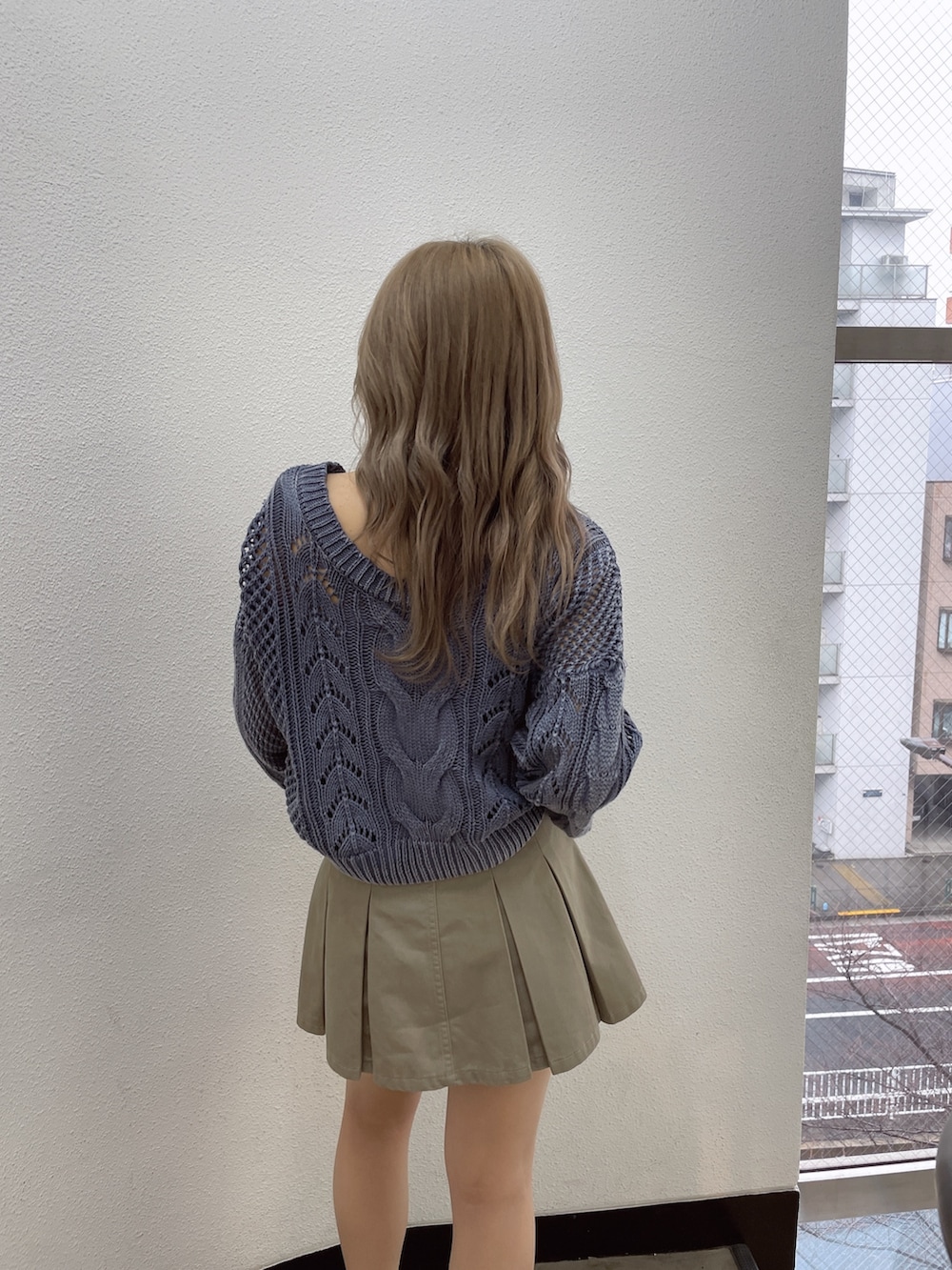 ブルー系のニット/セーター、ベージュ系のスカート、ブラック系のサンダルを着用したレディースの冬コーディネートの4枚目の写真