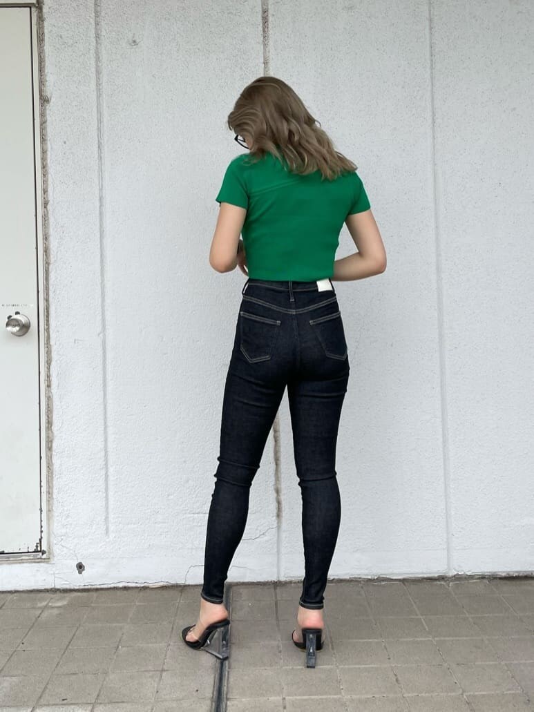 ブラック系のサンダル、ブラック系のデニムパンツ、グリーン系のニット/セーターを着用したレディースの夏コーディネートの2枚目の写真