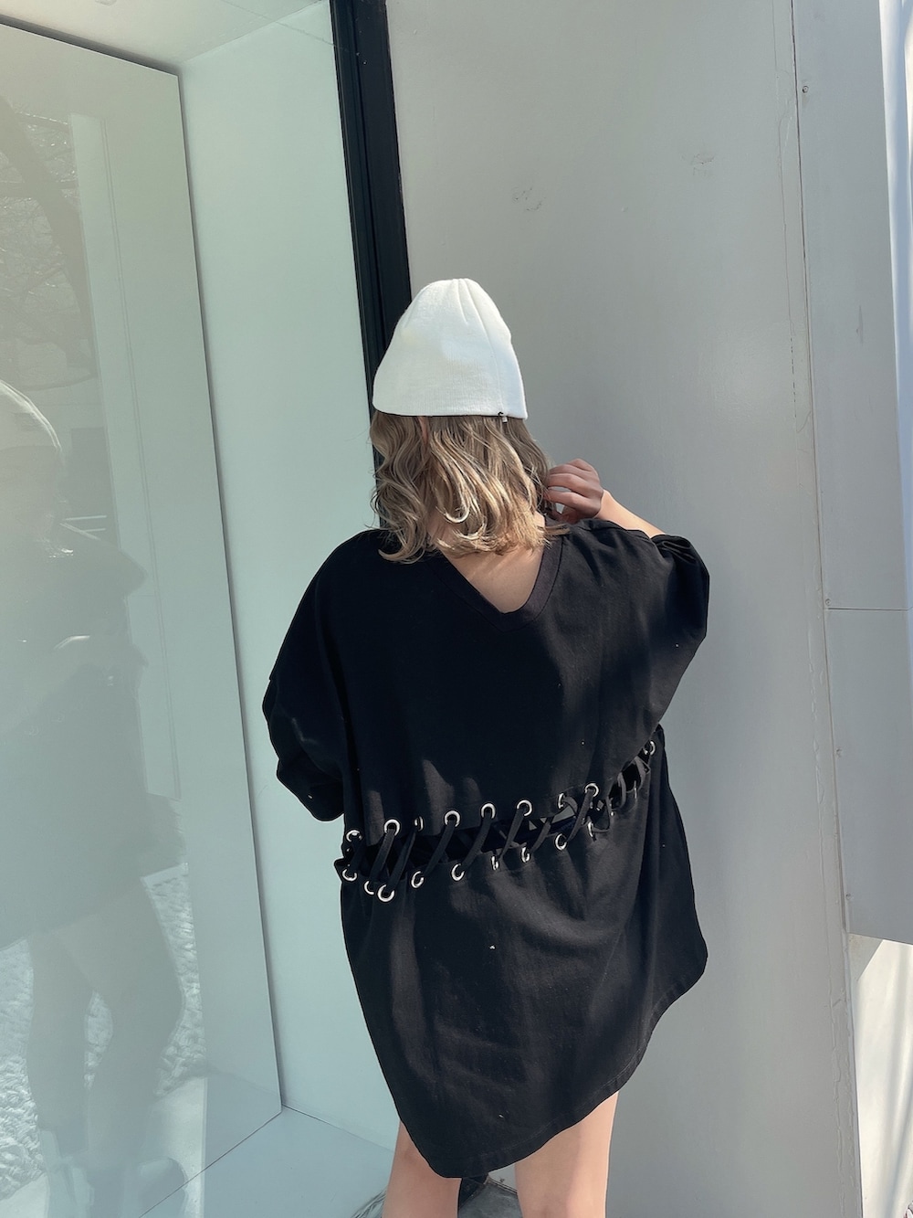 ブラック系のTシャツ/カットソー、ホワイト系のブーツ、ホワイト系のニットキャップ/ビーニーを着用したレディースの冬コーディネートの6枚目の写真