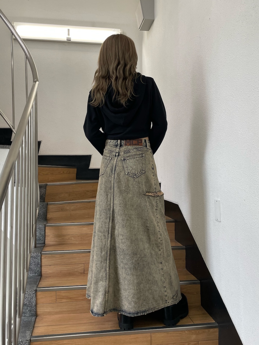 ブラック系のパーカー、ブルー系のデニムスカートを着用したレディースの秋コーディネートの4枚目の写真