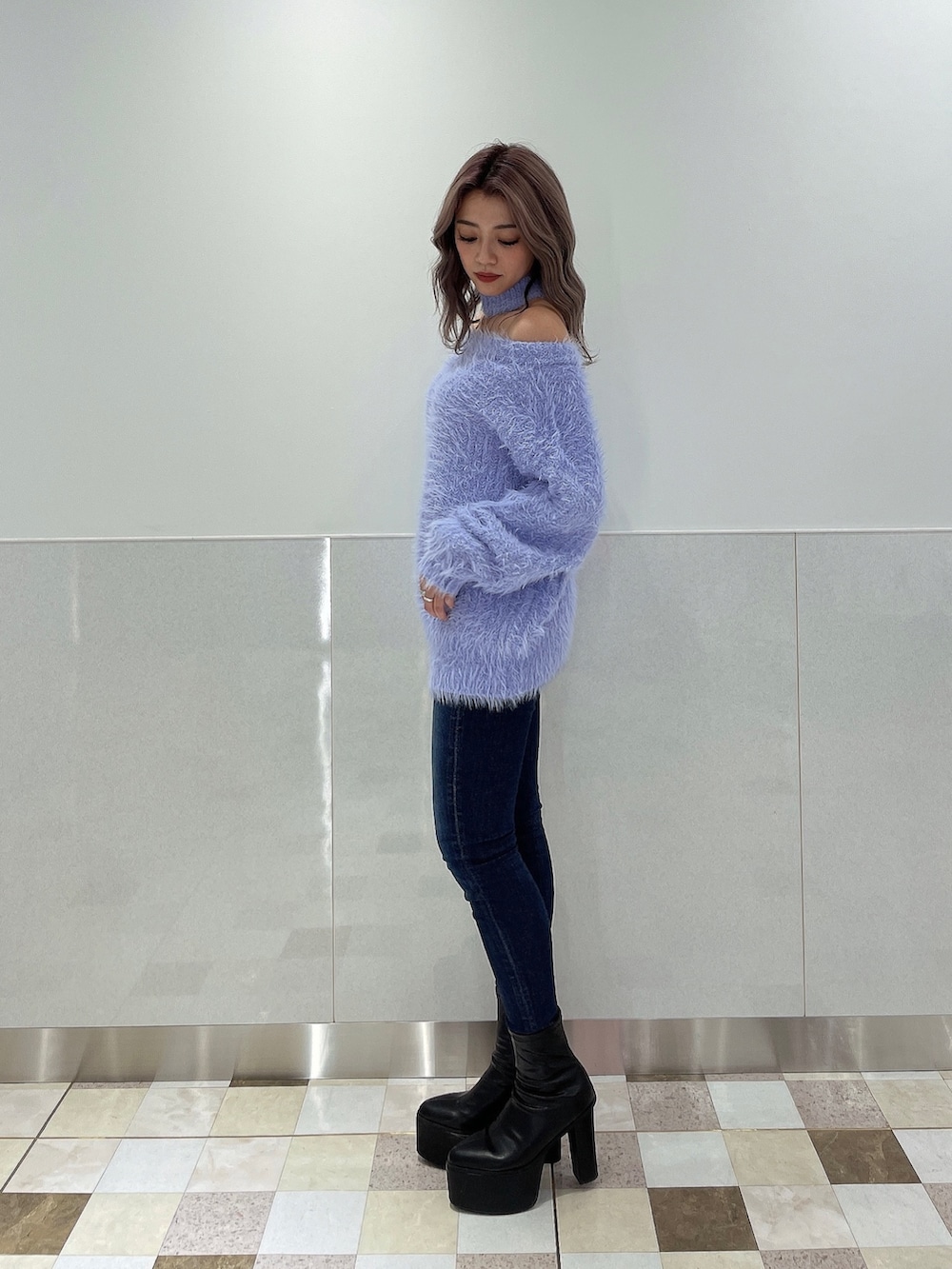 パープル系のニット/セーター、ブルー系のデニムパンツ、ブラック系のブーツを着用したレディースの秋コーディネートの6枚目の写真