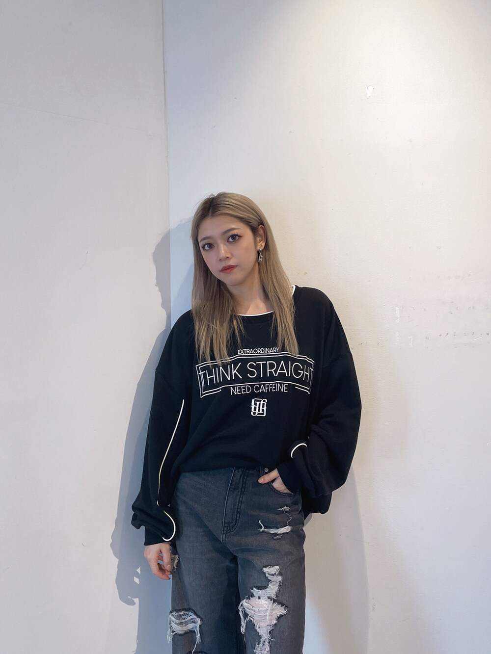 ブラック系のスウェット、ブラック系のデニムパンツ、ブラック系のブーツを着用したレディースの秋コーディネートの4枚目の写真