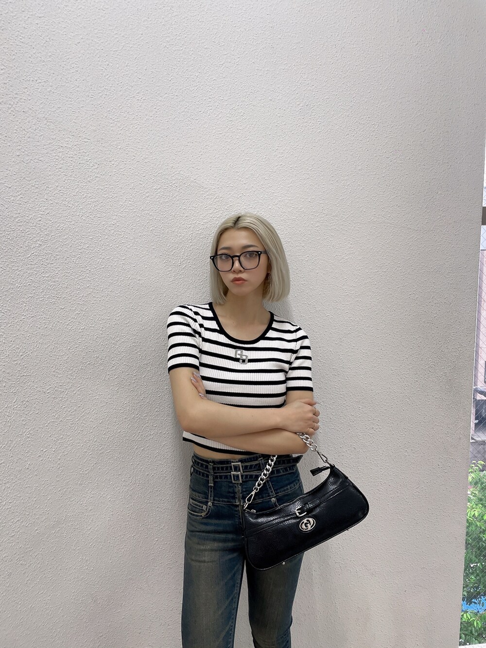 その他のニット/セーター、ブルー系のデニムパンツ、ブラック系のハンドバッグを着用したレディースの夏コーディネートの2枚目の写真