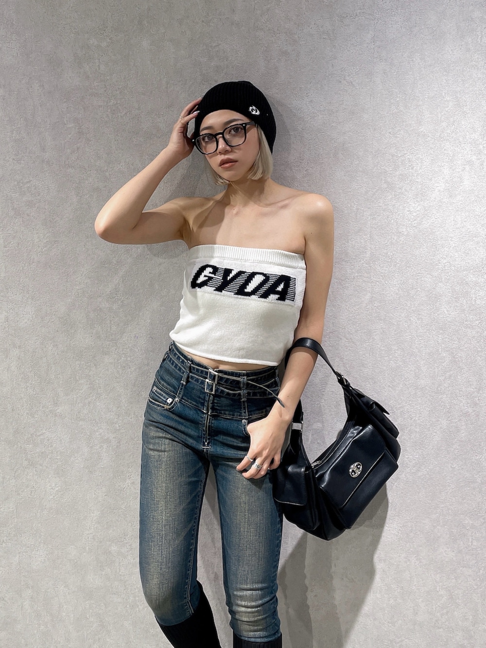 ホワイト系のニット/セーター、ブルー系のデニムパンツ、ブラック系のブーツを着用したレディースの夏コーディネートの4枚目の写真