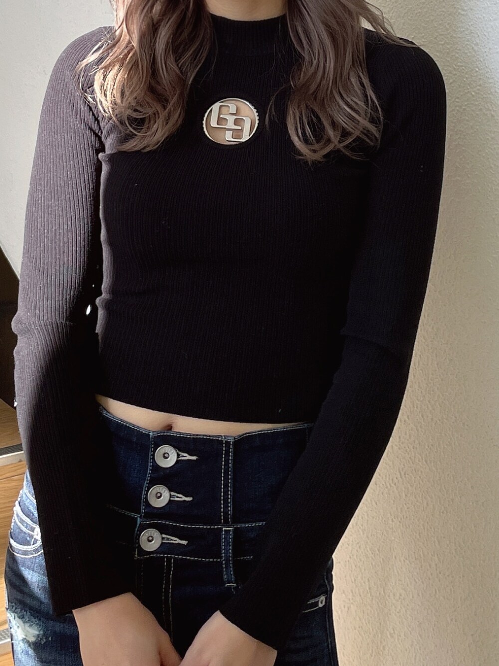 ブラック系のニット/セーター、ブラック系のパンプス、ブルー系のデニムパンツを着用したレディースの冬コーディネートの6枚目の写真