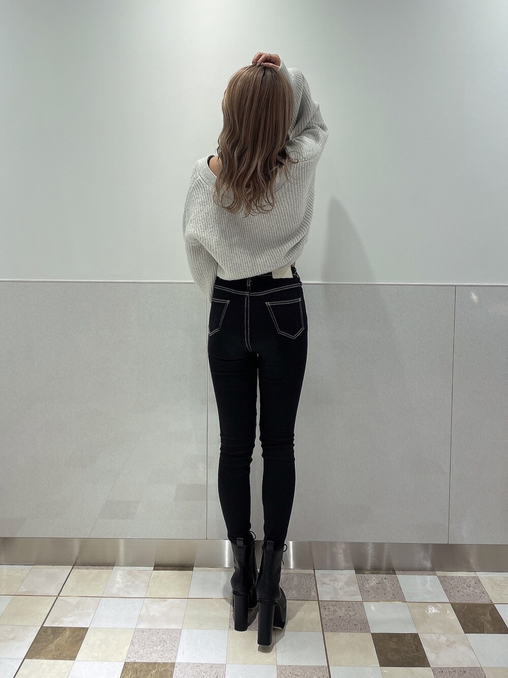 ホワイト系のニット/セーター、ブラック系のデニムパンツ、ブラック系のブーツを着用したレディースの秋コーディネートの2枚目の写真