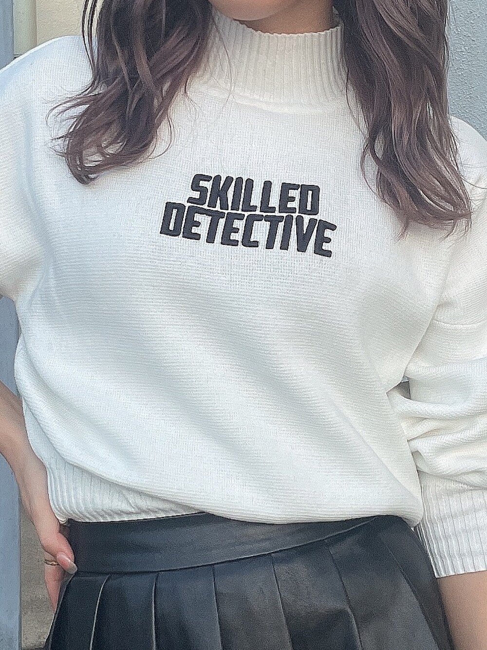 ホワイト系のニット/セーター、ブラック系のスカート、ブラック系のブーツを着用したレディースの秋コーディネートの7枚目の写真