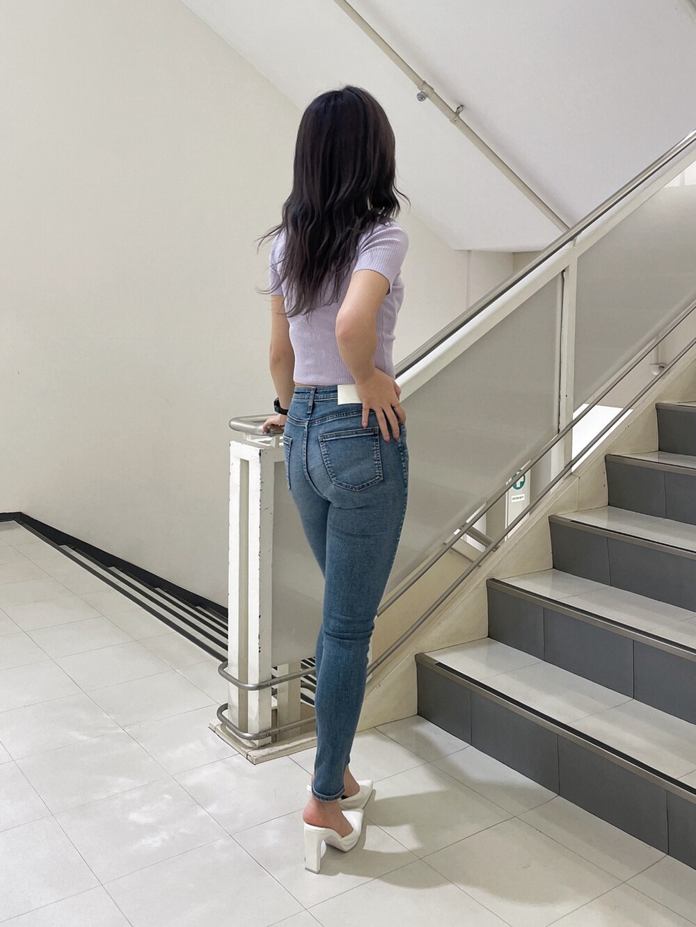 ブルー系のデニムパンツ、ホワイト系のパンプス、パープル系のTシャツ/カットソーを着用したレディースの春コーディネートの2枚目の写真