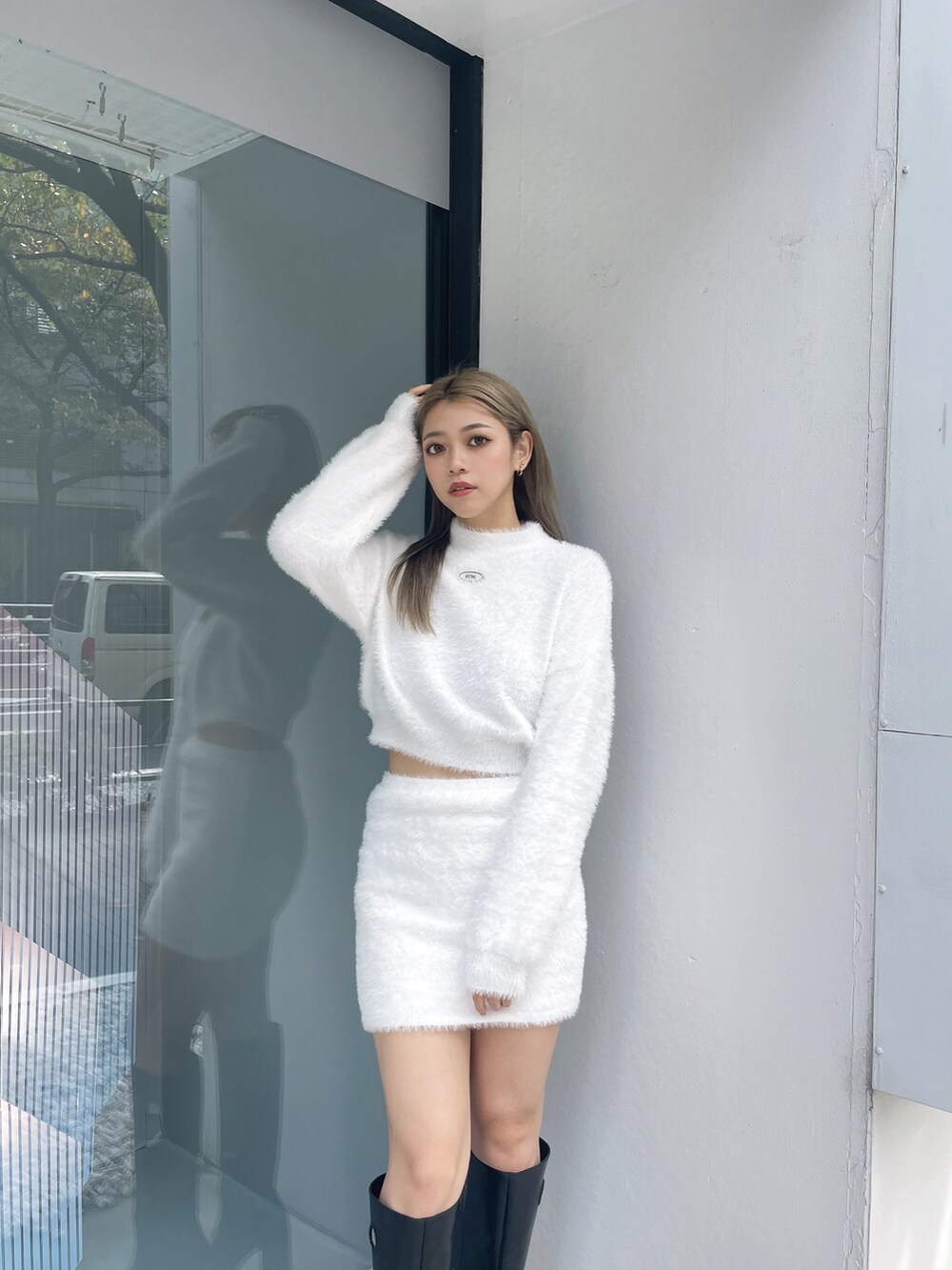 ホワイト系のニット/セーター、ホワイト系のスカート、ブラック系のブーツを着用したレディースの冬コーディネートの3枚目の写真