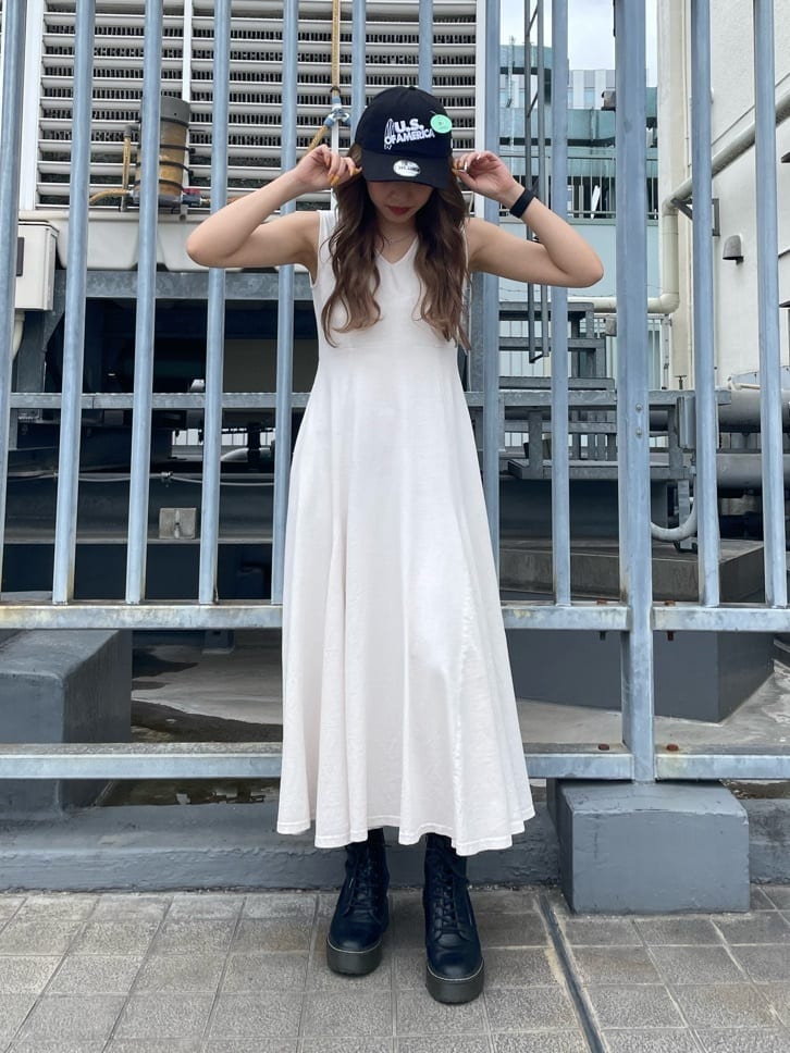 ホワイト系のワンピース、ブラック系のキャップを着用したレディースの春コーディネートの2枚目の写真