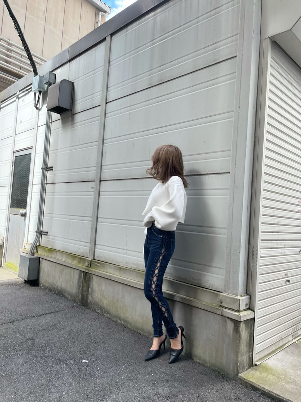 ブラック系のパンプス、ブルー系のデニムパンツ、ホワイト系のニット/セーターを着用したレディースの秋コーディネートの2枚目の写真