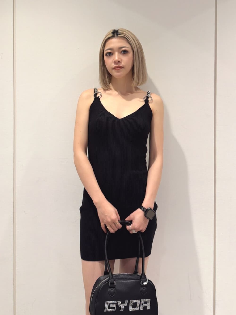 ブラック系のブーツ、ブラック系のボストンバッグ、ブラック系のワンピースを着用したレディースの夏コーディネートの4枚目の写真