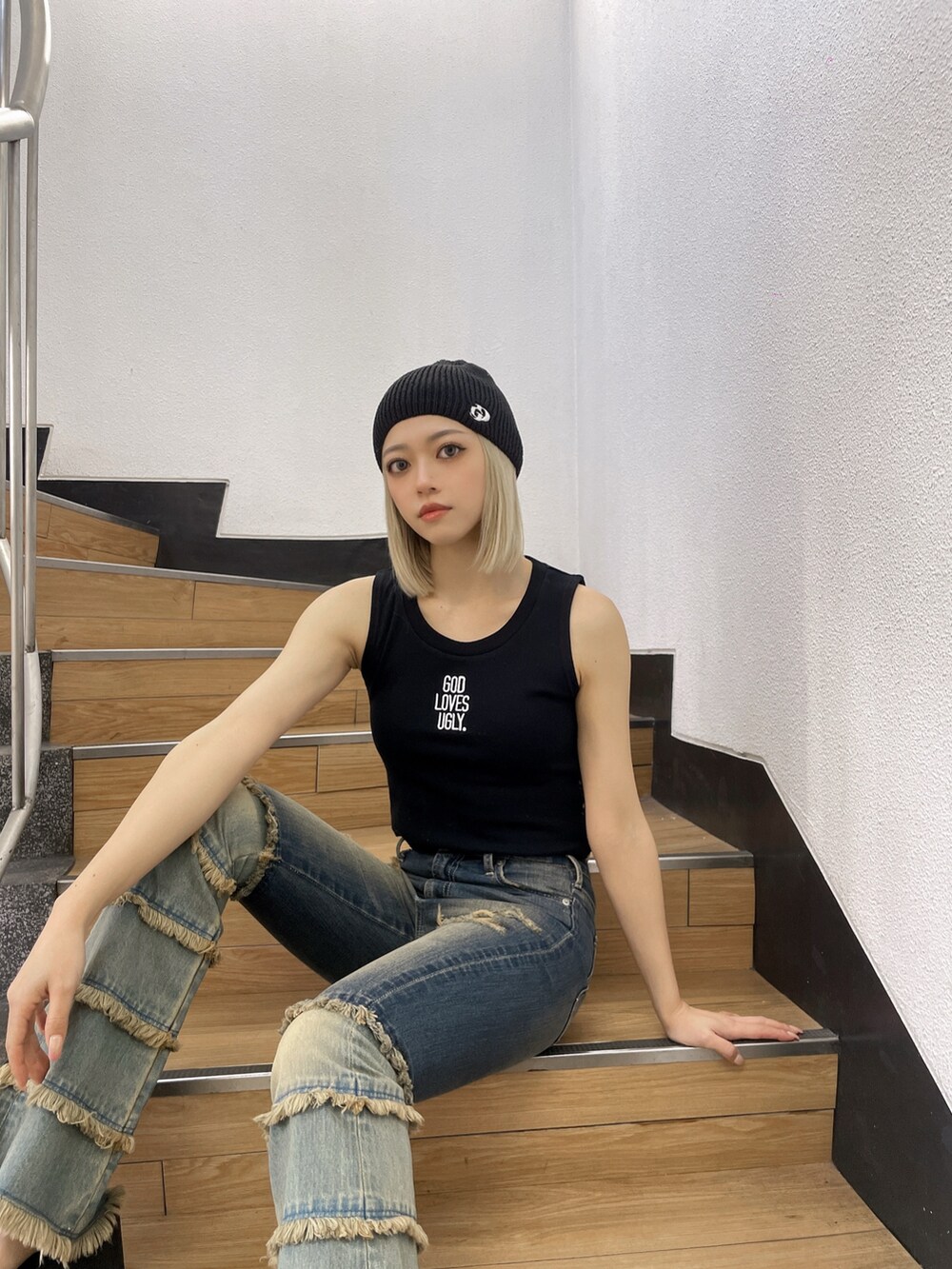 ブラック系のタンクトップ、ブルー系のデニムパンツ、ブラック系のサンダルを着用したレディースの夏コーディネートの3枚目の写真