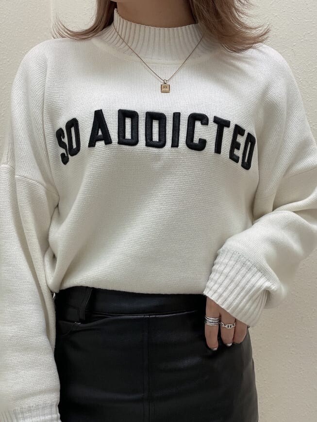 ブラック系のスカート、ブラック系のブーツ、ホワイト系のニット/セーターを着用したレディースの秋コーディネートの4枚目の写真