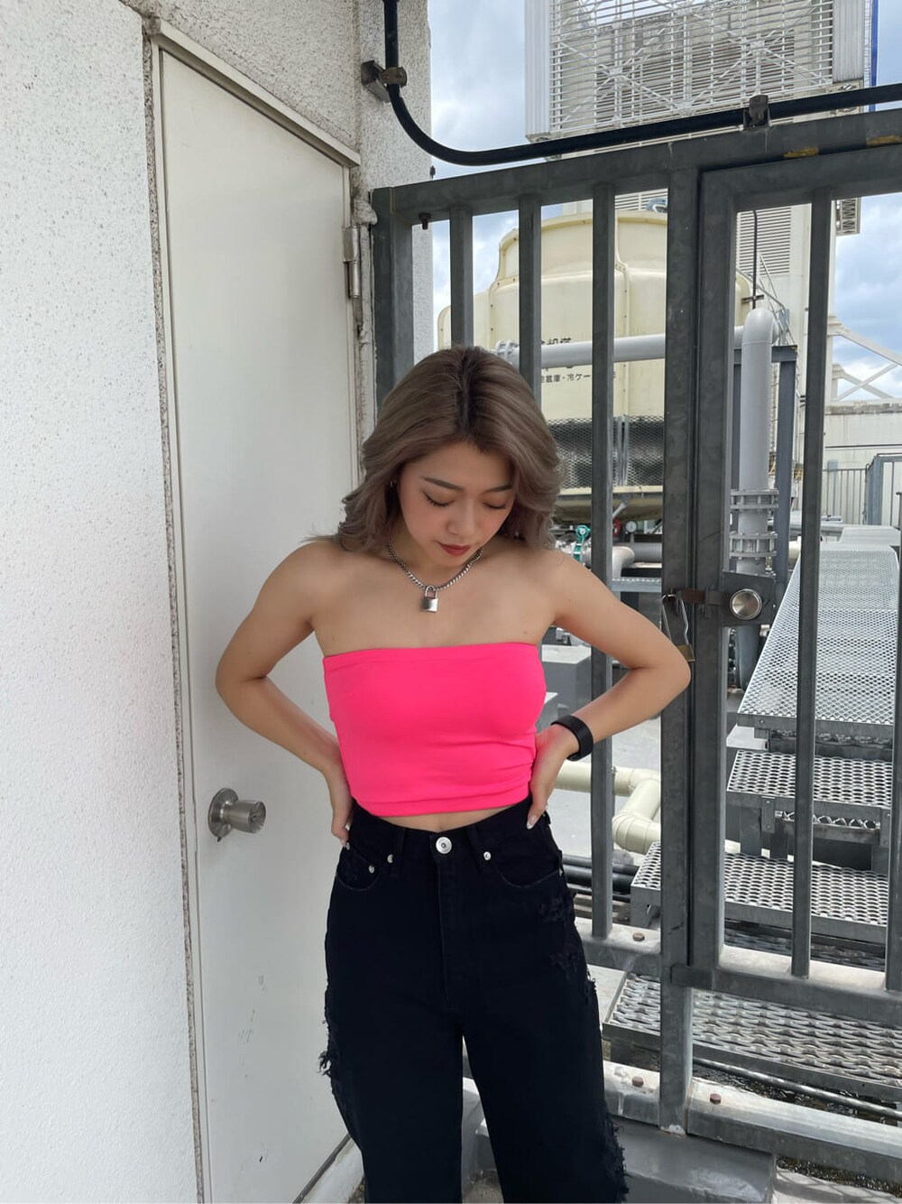 ブラック系のサンダル、ブラック系のデニムパンツ、ピンク系のチューブトップを着用したレディースの夏コーディネートの2枚目の写真