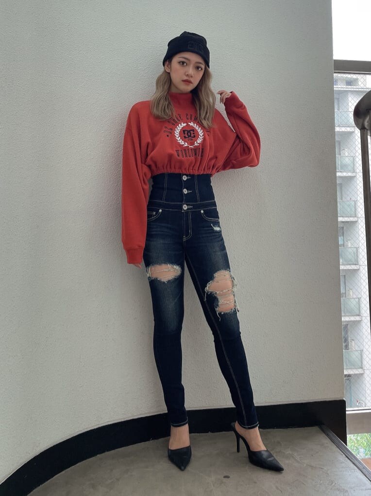 ブラック系のパンプス、ブルー系のデニムパンツ、オレンジ系のスウェットを着用したレディースの夏コーディネートの2枚目の写真