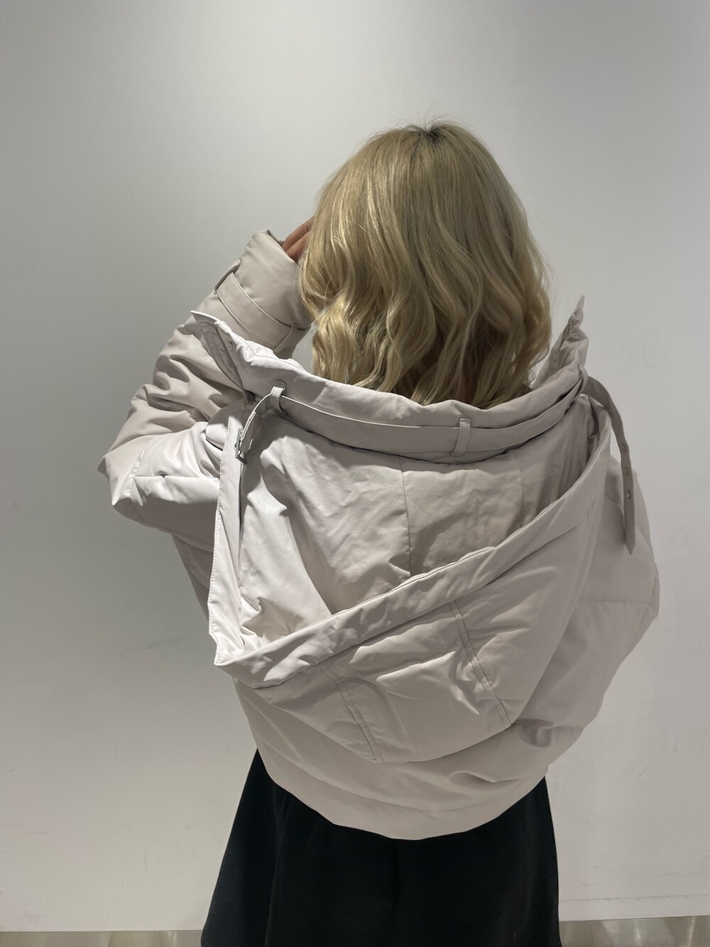 ブラック系のワンピース、ブラック系のブーツ、ホワイト系のダウンジャケット/コートを着用したレディースの冬コーディネートの8枚目の写真