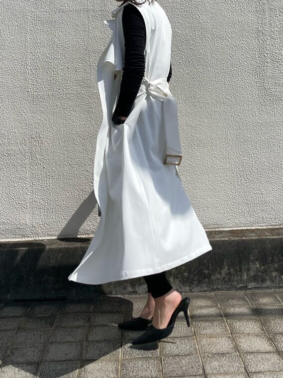 ブラック系のパンプス、ホワイト系のトレンチコートを着用したレディースの春コーディネートの2枚目の写真