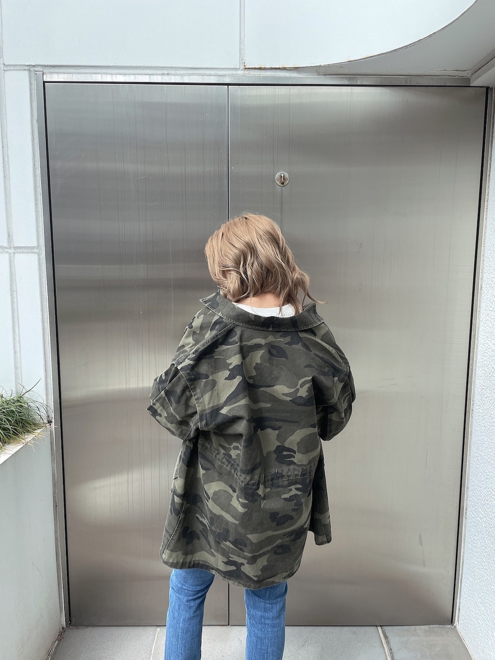 その他のミリタリージャケット、ブルー系のデニムパンツ、ホワイト系のスウェットを着用したレディースの春コーディネートの4枚目の写真