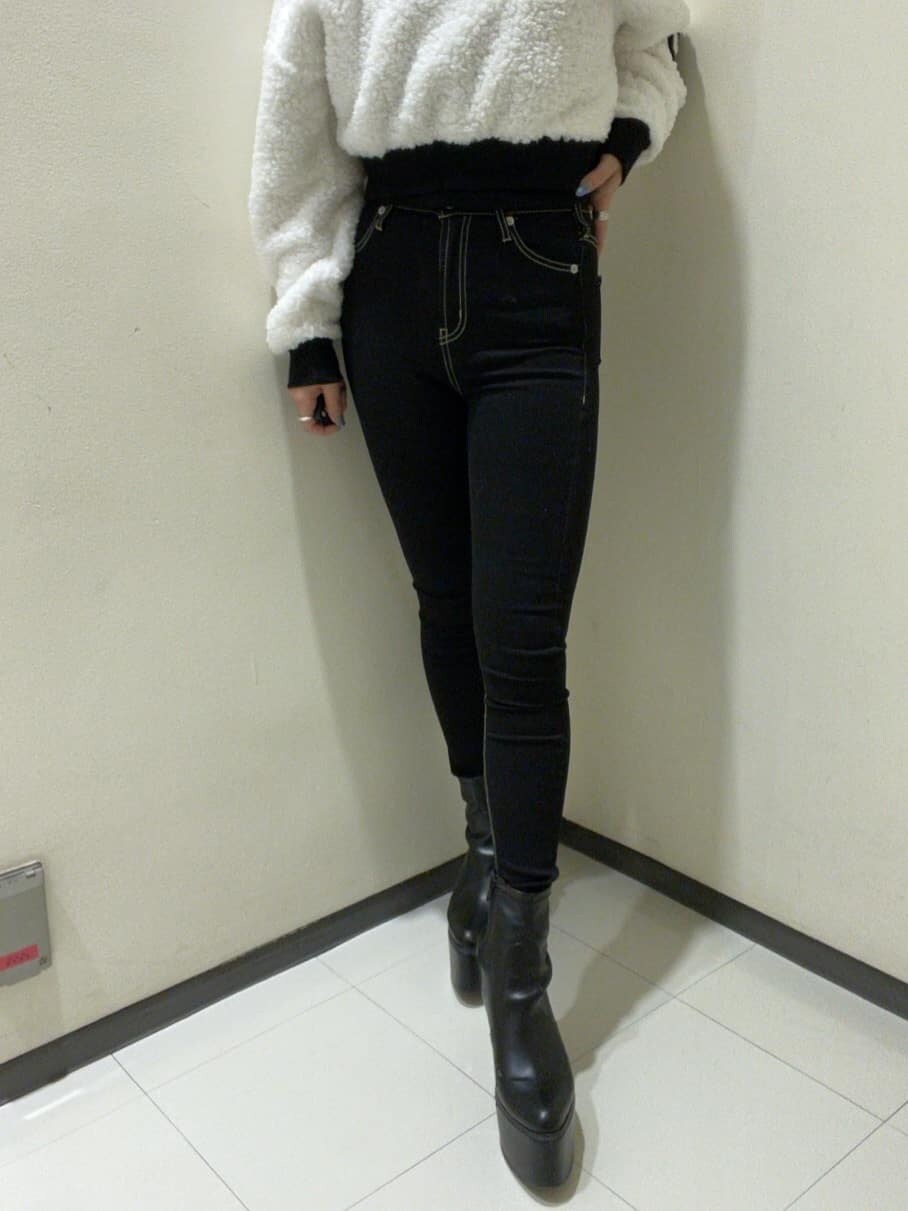 ブラック系のデニムパンツ、ブラック系のブーツ、ホワイト系のTシャツ/カットソーを着用したレディースの秋コーディネートの6枚目の写真