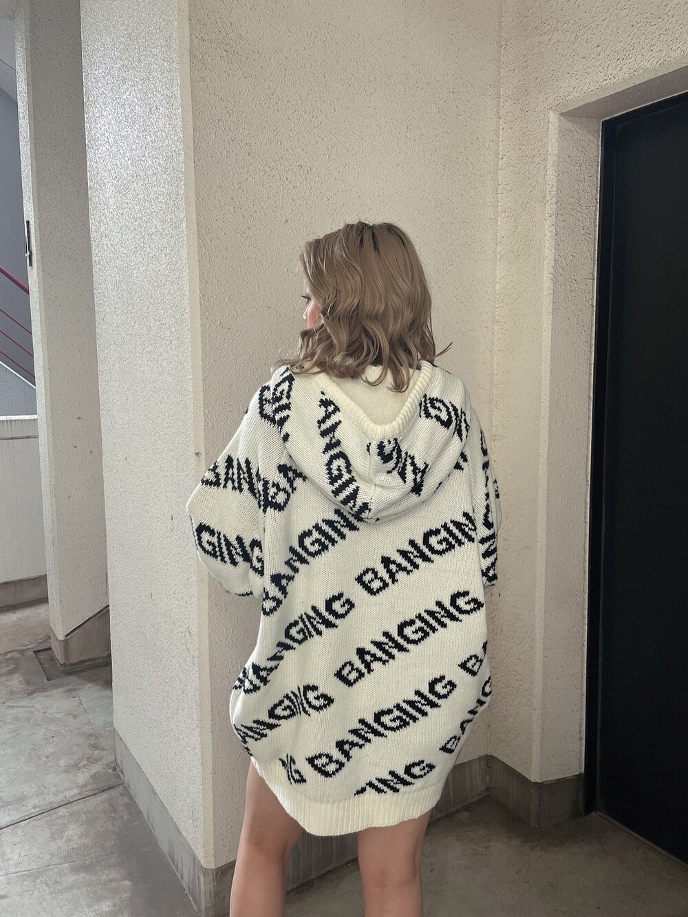 ホワイト系のニット/セーター、ホワイト系のブーツを着用したレディースの冬コーディネートの6枚目の写真