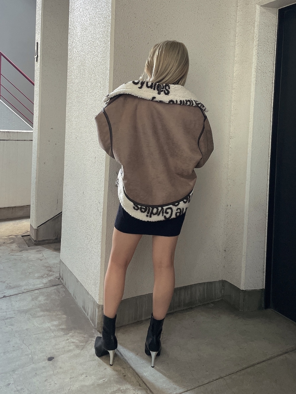 ブラック系のワンピース、ブラック系のブーツを着用したレディースの秋コーディネートの4枚目の写真