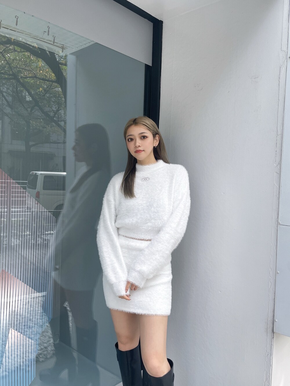 ホワイト系のニット/セーター、ホワイト系のスカート、ブラック系のブーツを着用したレディースの冬コーディネートの4枚目の写真