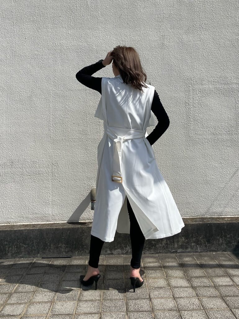 ブラック系のパンプス、ホワイト系のトレンチコートを着用したレディースの春コーディネートの3枚目の写真