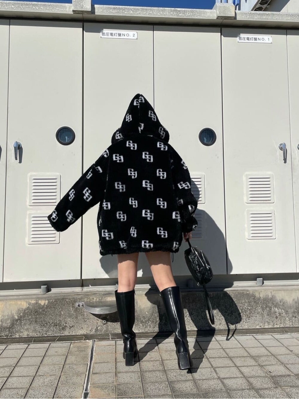 ブラック系のニット/セーター、ブラック系のブーツ、ブラック系のスカートを着用したレディースの秋コーディネートの2枚目の写真