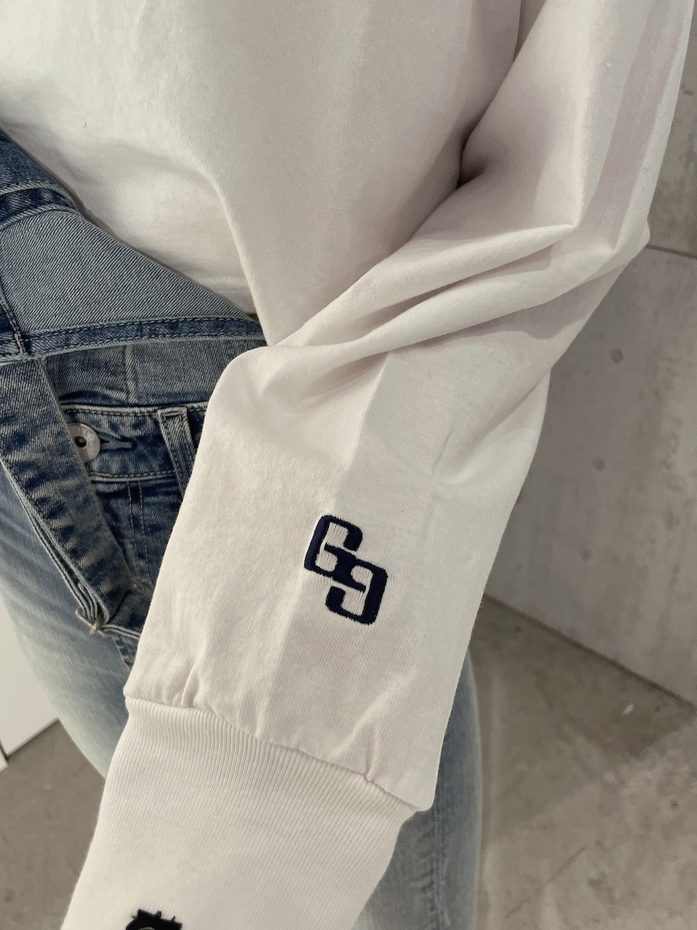 ホワイト系のTシャツ/カットソー、ブルー系のサロペット/オーバーオール、ホワイト系のパンプスを着用したレディースの冬コーディネートの7枚目の写真