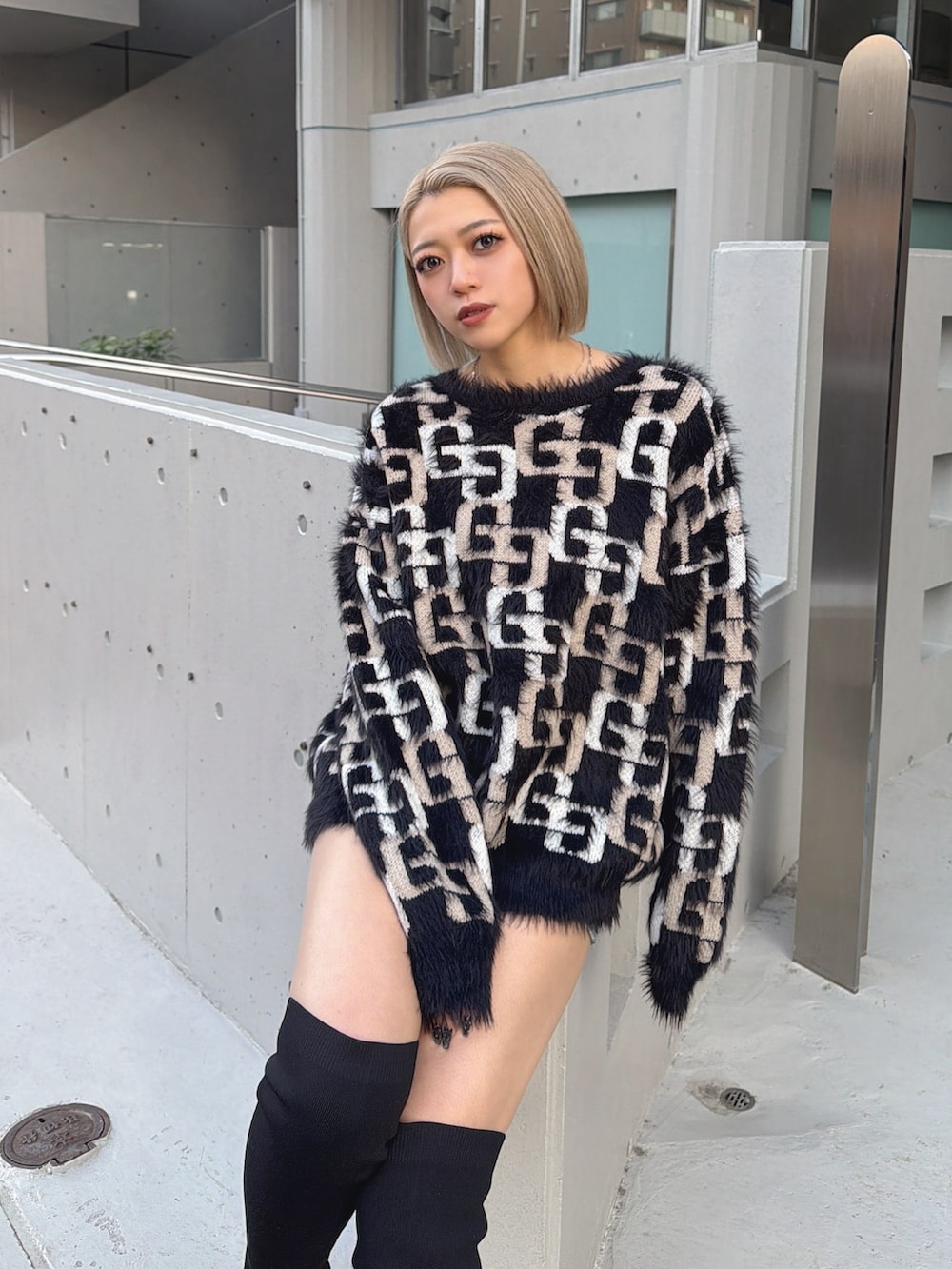 ブラック系のニット/セーター、ブラック系のブーツを着用したレディースの冬コーディネートの2枚目の写真